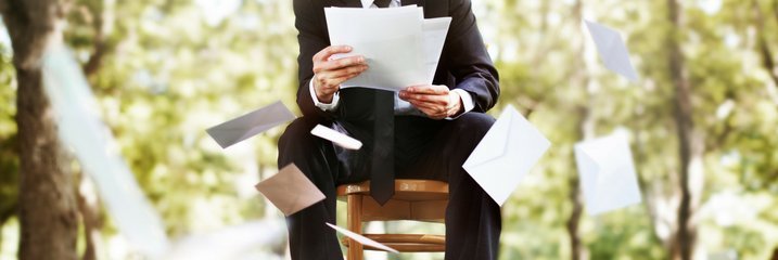 Man in chair throwing papers