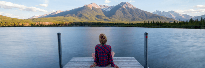 Woman sitting on dock on lake