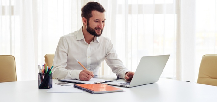 Bearded man checking his court-friendly PDF document and laptop with pencil in hand