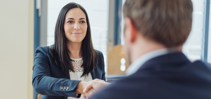 confident female lawyer shaking hand with client